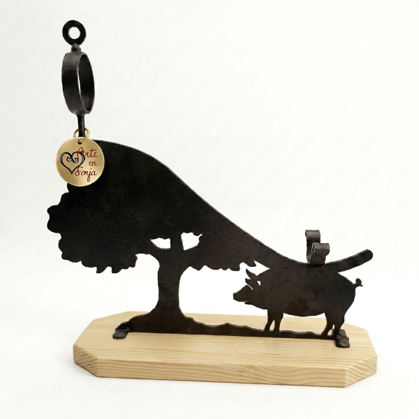 Jamonero de forja dehesa con chasis de hierro negro, motivo ibérico recortado y base de madera maciza de pino.